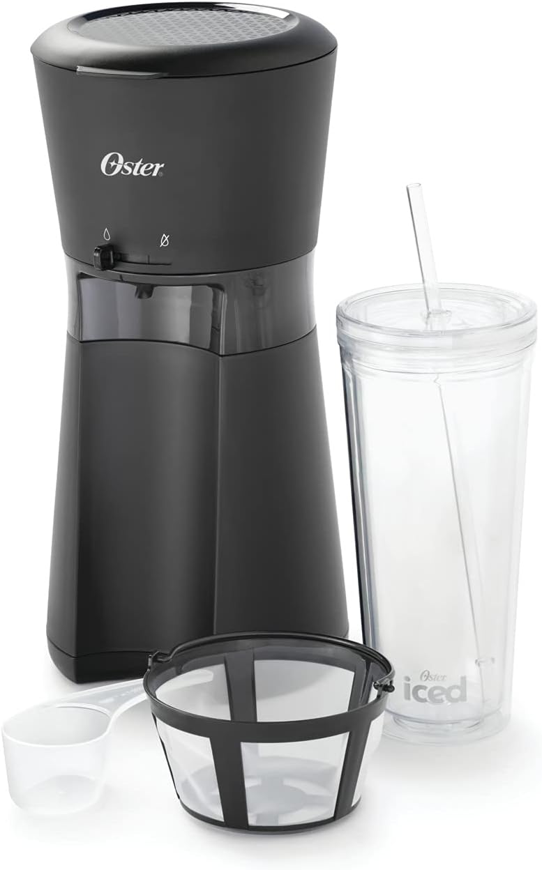 Oster IcedCoffee Maker with all included components: the black coffee maker unit, a clear reusable tumbler with lid and straw, a coffee scoop, and a reusable coffee filter.