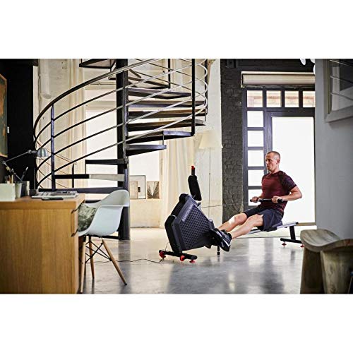 Utente che rema sul DOMYOS Domyos 500 in un ambiente domestico, mostrando il suo ingombro ridotto