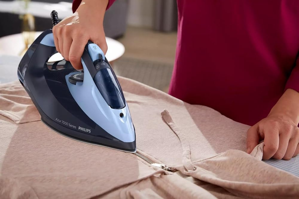 User ironing a garment with Philips Azur 7000 Series Steam Iron.