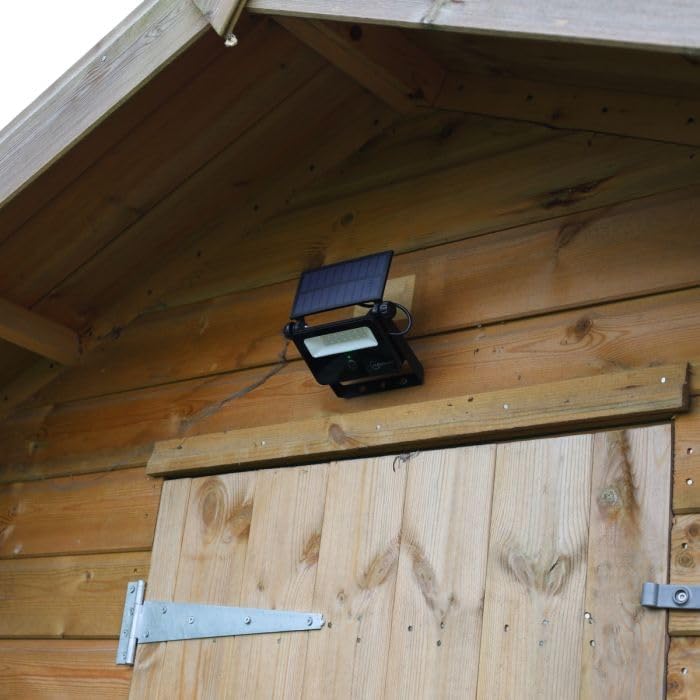 Auraglow solar security spotlight mounted on the side of a wooden shed, highlighting its wall-mount capability.