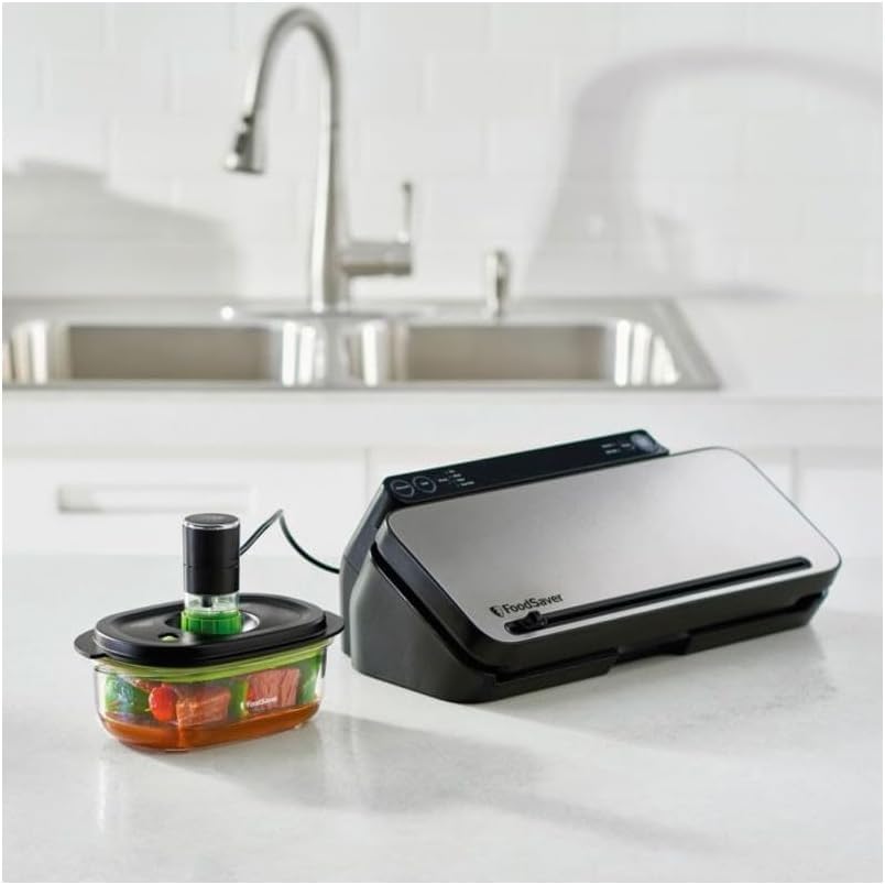 FoodSaver vacuum container connected to a FoodSaver vacuum sealing machine on a kitchen counter.