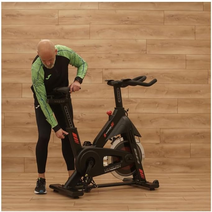 Man adjusting the seat position on the BH Vanquish Indoor Cycling Bike.