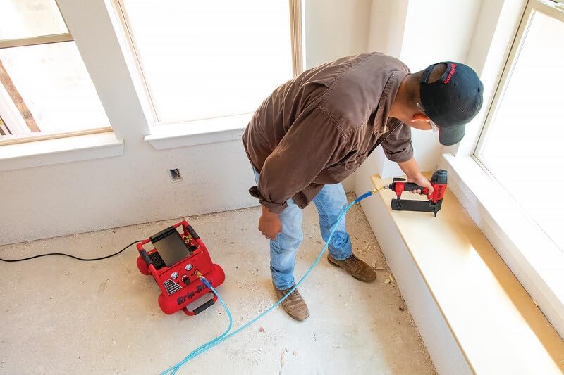 Worker using a finish nailer with an air compressor