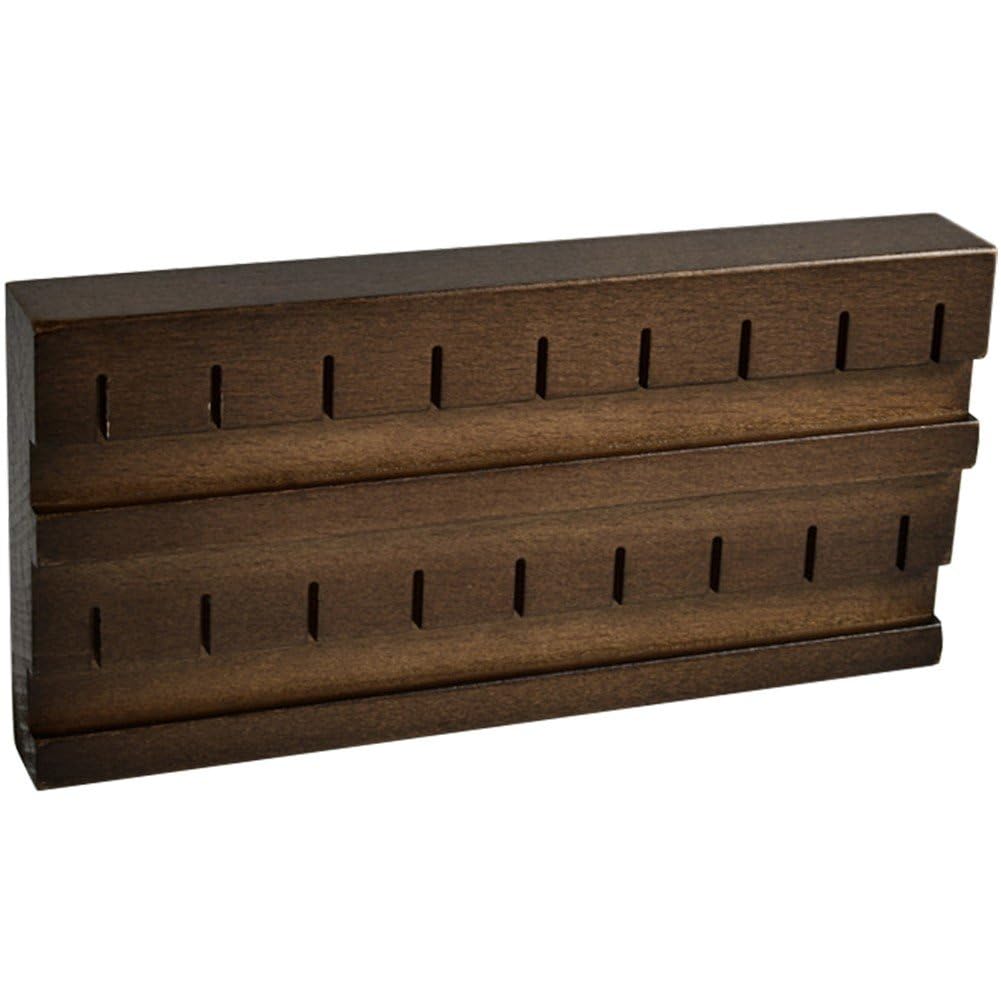 Anneau de nombril et piercing mis en valeur sur un support en bois massif