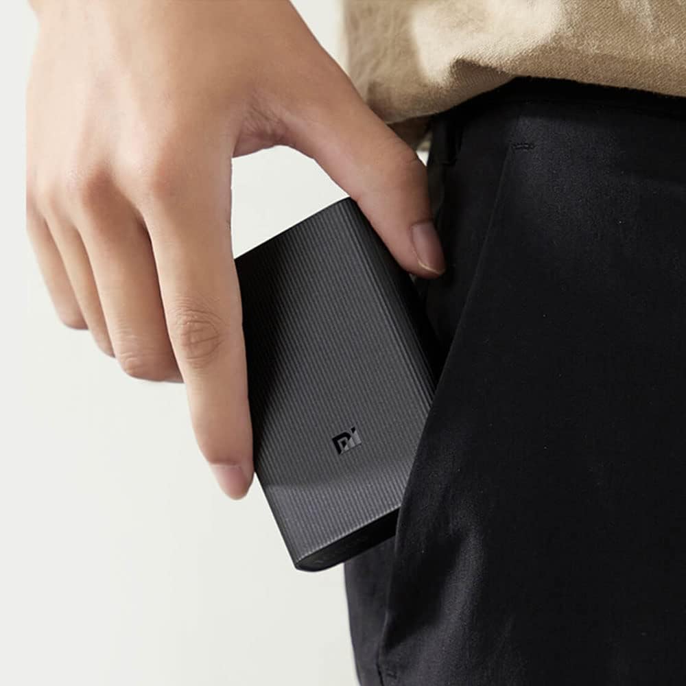 A hand holding the Xiaomi Mi Power Bank 3 Ultra Compact, demonstrating its small size and portability.