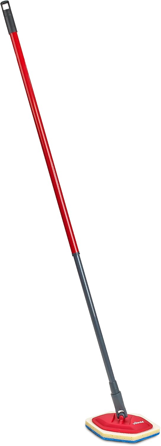 A hand holding the detached Vileda Bath Magic sponge to clean a sink basin.