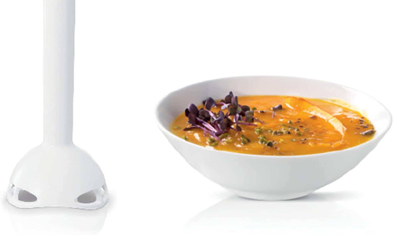 Immersion blender attachment next to a bowl of pureed soup