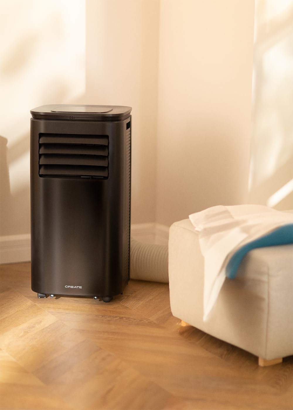 Mobile air conditioner placed in a room next to a window with the exhaust hose extended.