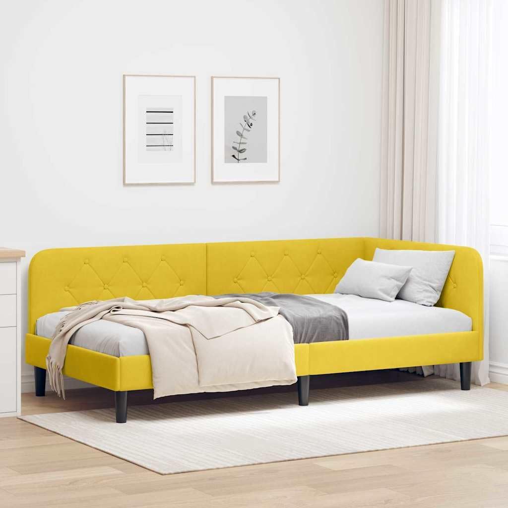 A bright yellow velvet corner day bed frame with a headboard, set up as a bed with white and grey bedding in a minimalist room.