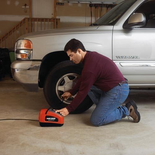 Man inflating a car tire with BLACK+DECKER ASI300-GB