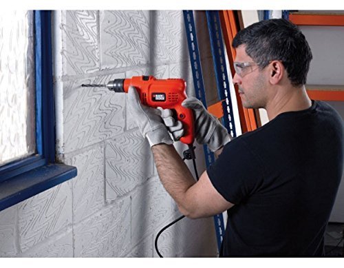 Man drilling into a masonry wall with BLACK+DECKER KR504RE