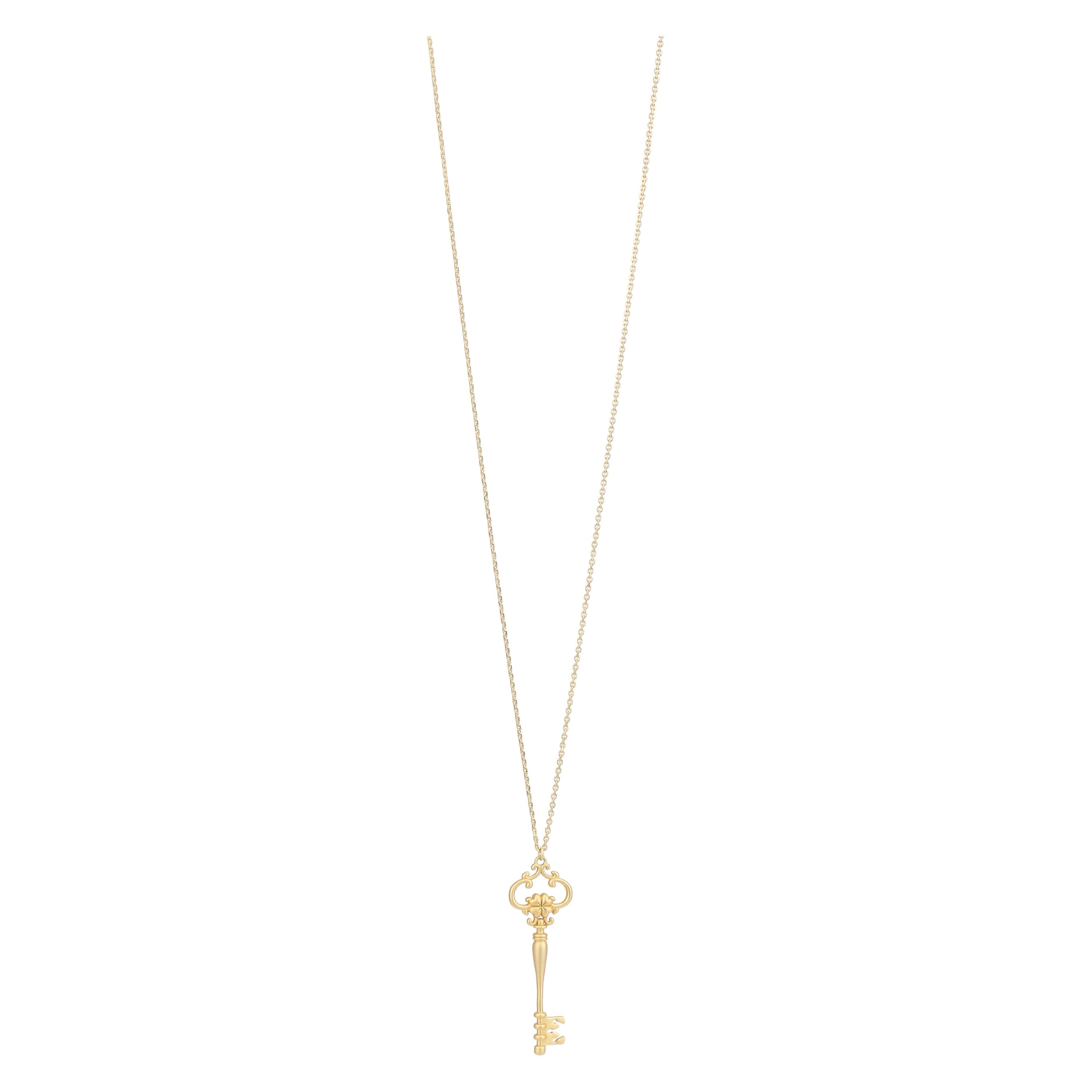 Collana lunga con pendente chiave con quadrifoglio