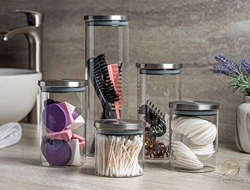 Person filling glass food-storage canisters with dry pantry ingredients on a kitchen counter