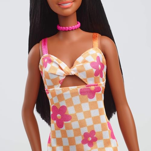 Barbie Fashionistas Poupée Printemps aux cheveux noirs, vêtue d’une robe midi à fleurs roses et à carreaux orange, d’un collier et de sandales, HYT91