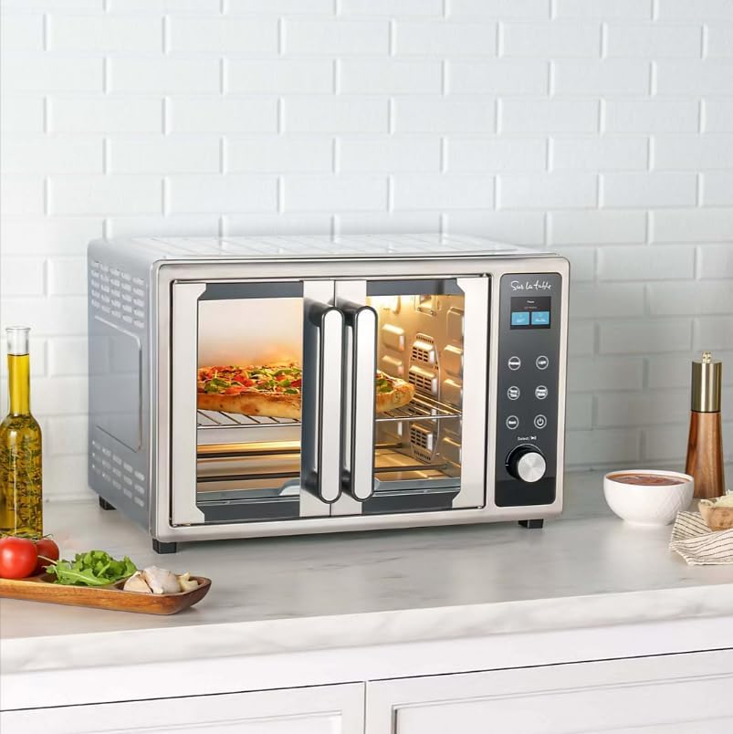 Interior view of the Sur La Table SLT-1832 French Door Air Fryer Toaster Oven with muffins baking on a rack, showing a red laser beam scanning the food, indicating AI cooking technology.