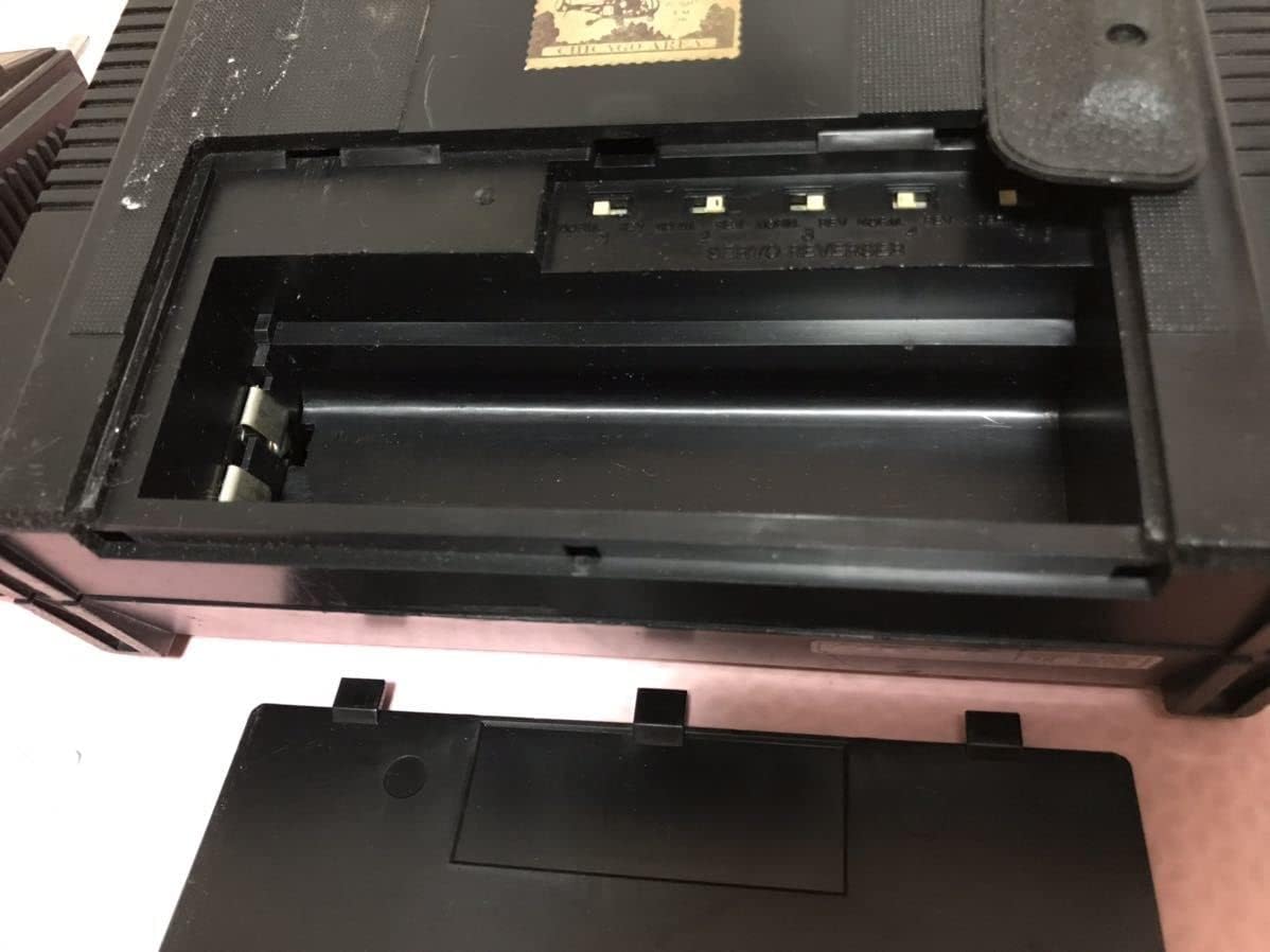 Open battery compartment of a FUTABA RC controller, showing empty slots for AA batteries from a slightly different angle.