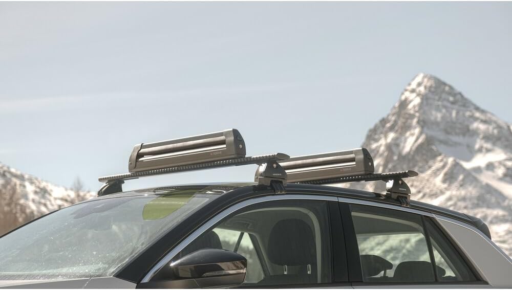 കാറിന്റെ മേൽക്കൂരയിലെ ബാറുകളിൽ ഘടിപ്പിച്ചിരിക്കുന്ന നോർഡ്രൈവ് പ്രോ-സ്ലൈഡർ ഇവോ അലുമിനിയം പിഎസ്-60 സ്കീ കാരിയറുകൾ അടച്ച് ഗതാഗതത്തിന് തയ്യാറാണ്.