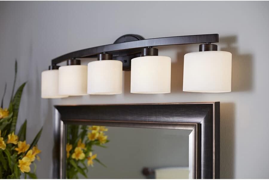 Close-up view of the Allen + Roth Vanity Light showing the aged bronze finish and glass shades