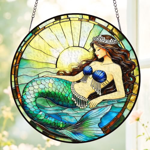 Round stained glass style suncatcher showing a mermaid with a green scaled tail against a sun, hung by its chain against bright window light