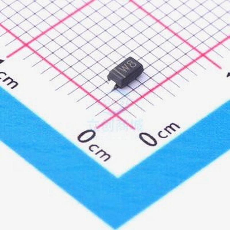 Zenerova dioda umístěná na mřížce s centimetrovými značkami pro porovnání velikostí.