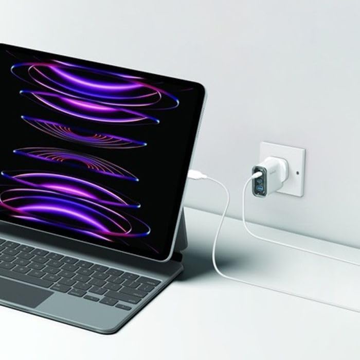 MOMAX 1-Charge Flow+ charger plugged into a wall outlet, charging a laptop
