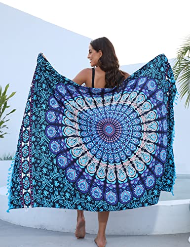 Mujer mostrando un pareo mandala en la piscina, destacando su vibrante estampado en tonos azules