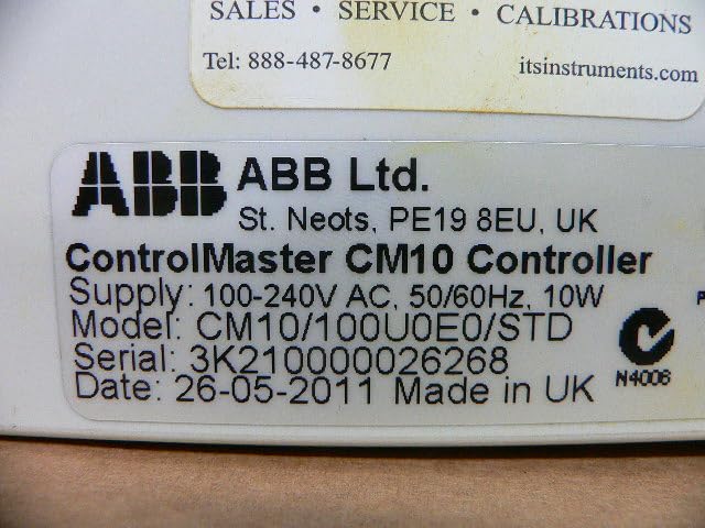 Close-up of the ABB CM10 Controller product label showing model number, serial number, and power specifications.