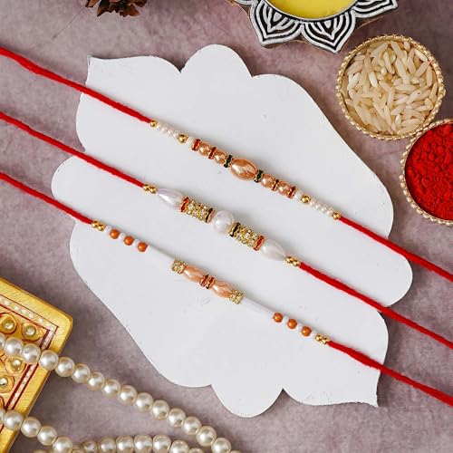 Image of eCraftIndia Red & Golden Set of 3 Trishul with Damru, Lord Ganesha, & Lord Krishna Playing Flute Religious Rakhis with Roli Chawal Pack