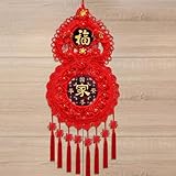 Chinesische Neujahrsdekoration mit roten Knoten, Quasten und roten Dekorationen. Jeder chinesische Knoten wird mit einem Seil gebunden und sieht nach der Fertigstellung von vorne und hinten gleich aus. Seine Symmetrie entspricht den ästhetischen Ansprüchen der Chinesen. Rot symbolisiert Glück und Wohlstand.