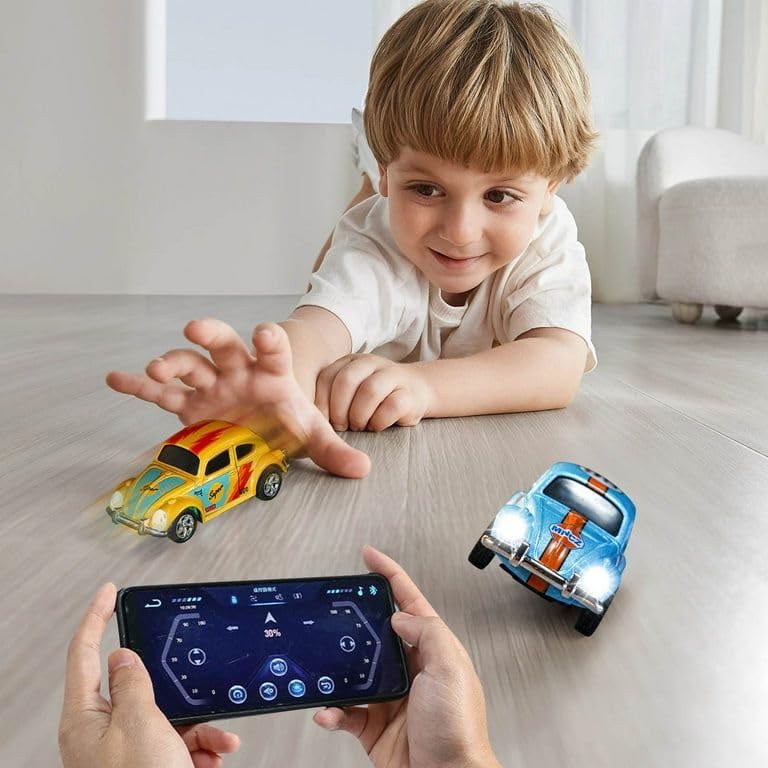 Child playing with two R/C cars, one yellow and one blue, controlled by a smartphone app