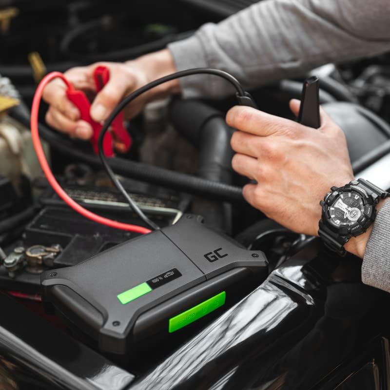 A person connecting the jumper cables from the Green Cell PowerBoost CJSGC01 to a car battery in an engine bay.
