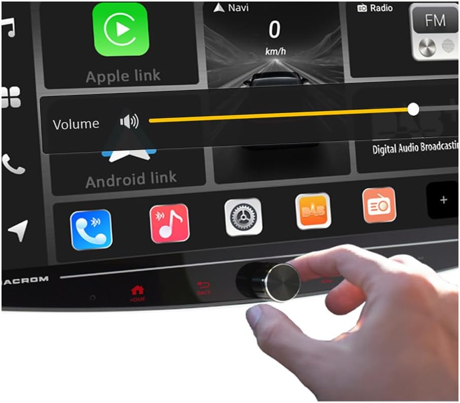 A hand adjusting the rotary volume knob on the Macrom T1003DAB monitor, with the volume level displayed on the screen.