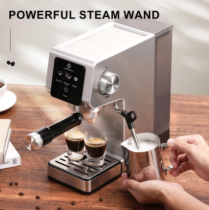 A hand frothing milk with the espresso machine's steam wand, creating microfoam in a stainless steel pitcher.