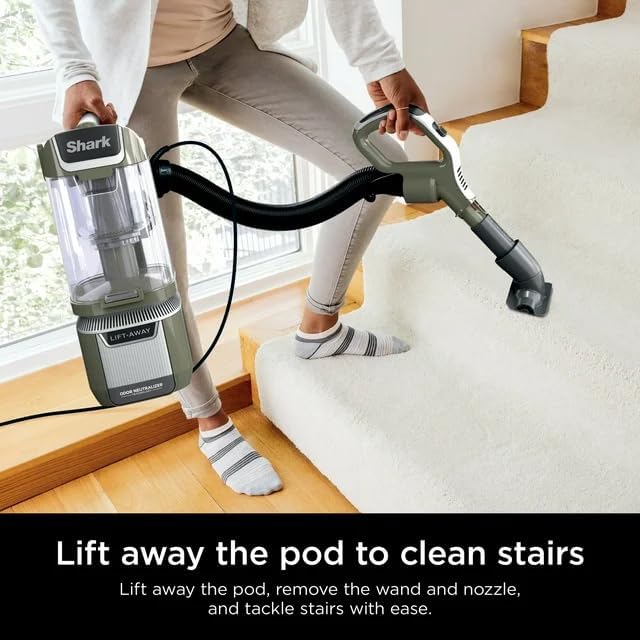 A person using the Shark Lift-Away vacuum in portable mode to clean carpeted stairs with an attachment.