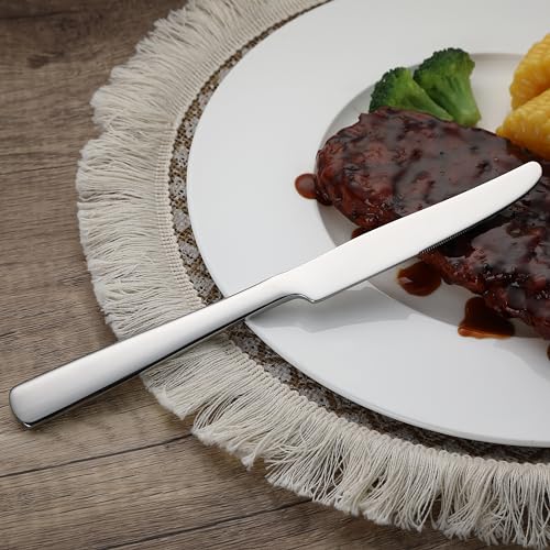 Cuchillo de mesa de acero inoxidable junto a un plato con comida, demostrando su uso práctico en cenas