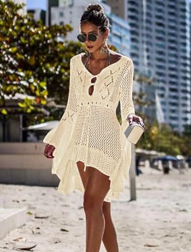 Modelo caminando por la playa con un vestido de punto color crema y gafas de sol, mostrando un estilo relajado y elegante.