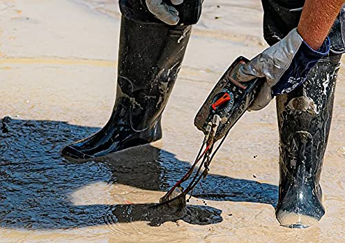 A person wearing protective boots and gloves retrieving the Sonel CMM 30 Multimeter from a muddy area, highlighting its ease of handling even when dirty.