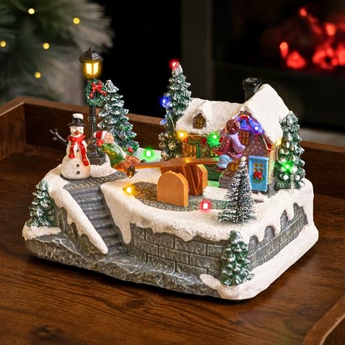 Marco Paul Animated See-Saw Christmas Village Scene - Large 15cm Musical Christmas Ornaments with Multi-Coloured LED Lights - Battery Operated Light Up Xmas Ornaments