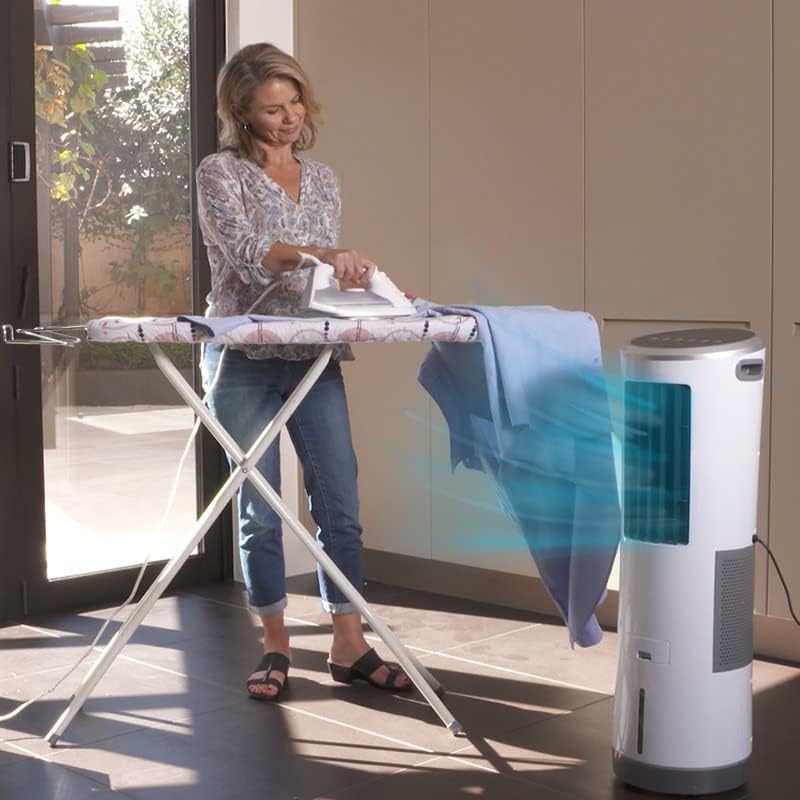 Woman ironing clothes with the Livington InstaChill air cooler providing cool air nearby.