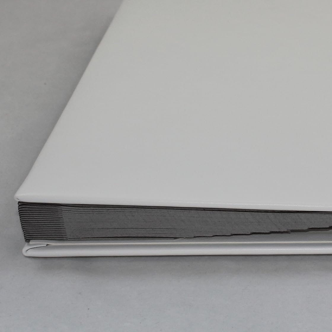Unterschriftenmappe aus glattem Vollrindleder in Weiß, Softcover, dehnbarer Rücken, 20 Register-Trennblätter aus stabiler grauer Kartonage, Aufnahme von DIN A4, Prägungen auf Anfrage