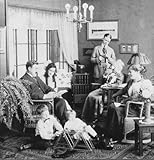 Historic image in black and white of a three generation family gathered in a living room grandmother viewing slides with a stereoscope some members reading and the children playing with toys on the floor Poster Print by John Short (15 x 16)