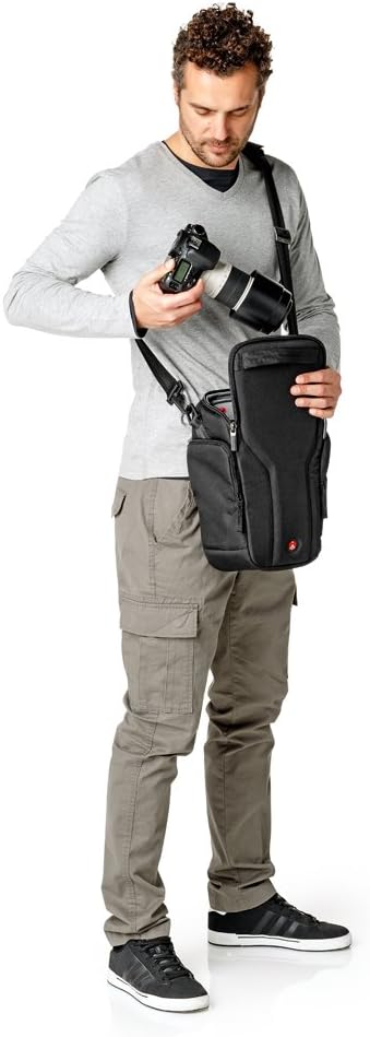 User wearing the Manfrotto Pro Holster Plus 40 bag, accessing a DSLR camera with a long lens from the open main compartment.