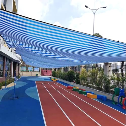 Toldo con ojales y tela azul y blanca que soluciona la falta de sombra en el jardín 4