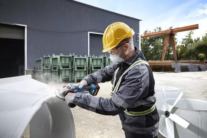 Worker using BOSCH angle grinder to grind a large white curved surface