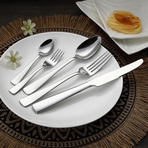 Juego de cubiertos de acero inoxidable elegantemente dispuesto en un plato con un fondo decorativo