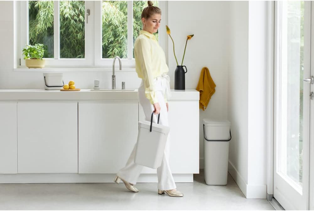 Person carrying Brabantia Sort & Go bin in a kitchen