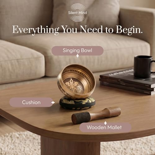 Tibetan singing bowl set with cushion and wooden mallet on a coffee table.