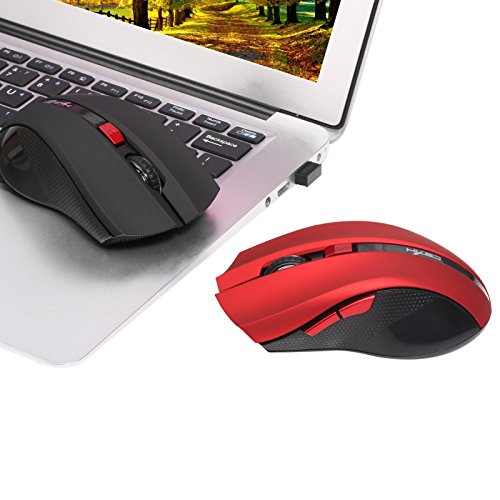 The red HXSJ X50 wireless mouse positioned next to a laptop, demonstrating its compact size and wireless functionality