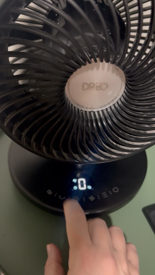 Close-up of the fan's control panel with various touch buttons for power, speed, timer, oscillation, and mute.