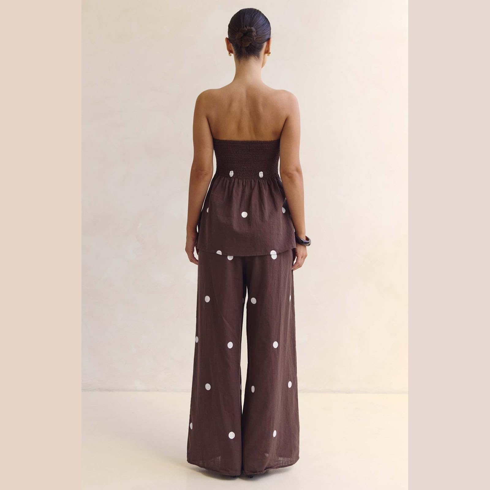 Ensemble deux pièces à pois pour femme : haut bustier sans bretelles et pantalon large taille haute. Collection été 2026.
